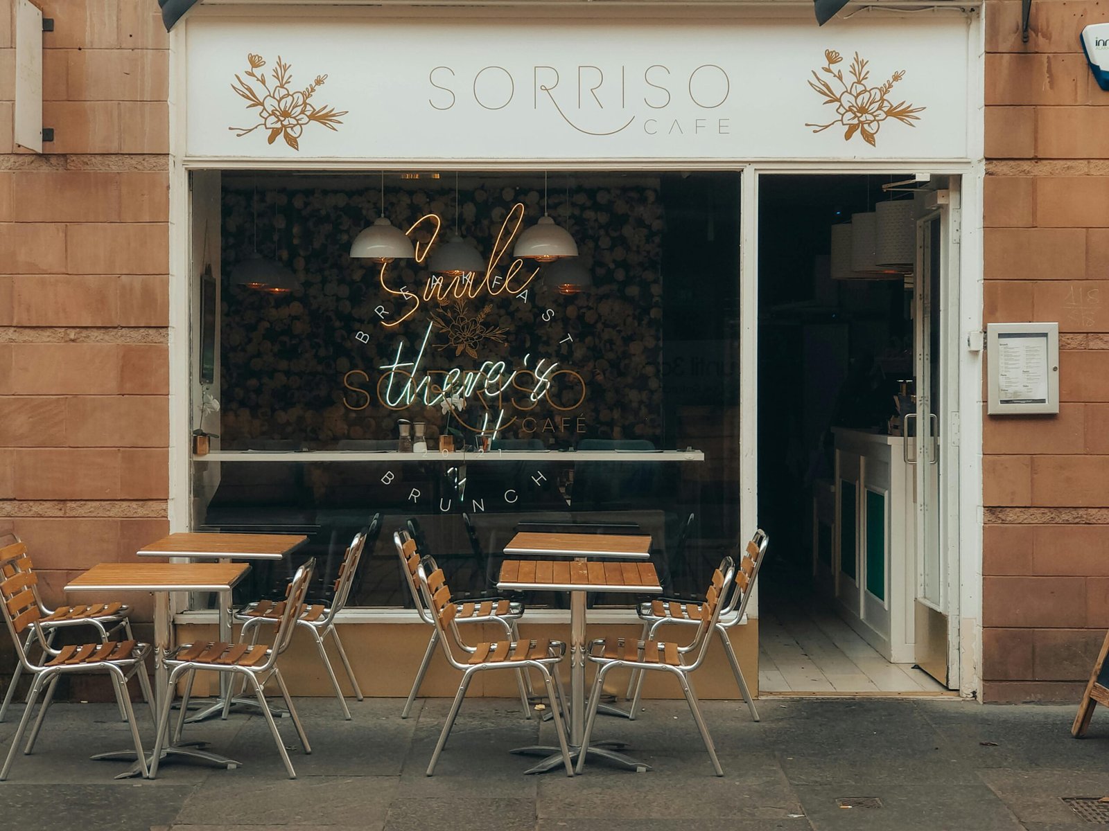 Exterior view of 'Sorriso Café' with outdoor seating on a city street, capturing a cozy atmosphere.